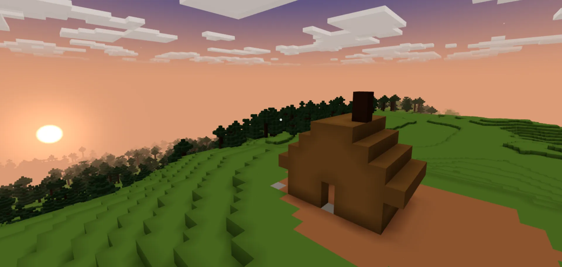 A player-built blocky dirt shelter with a chimney on a green hillside at sunset.