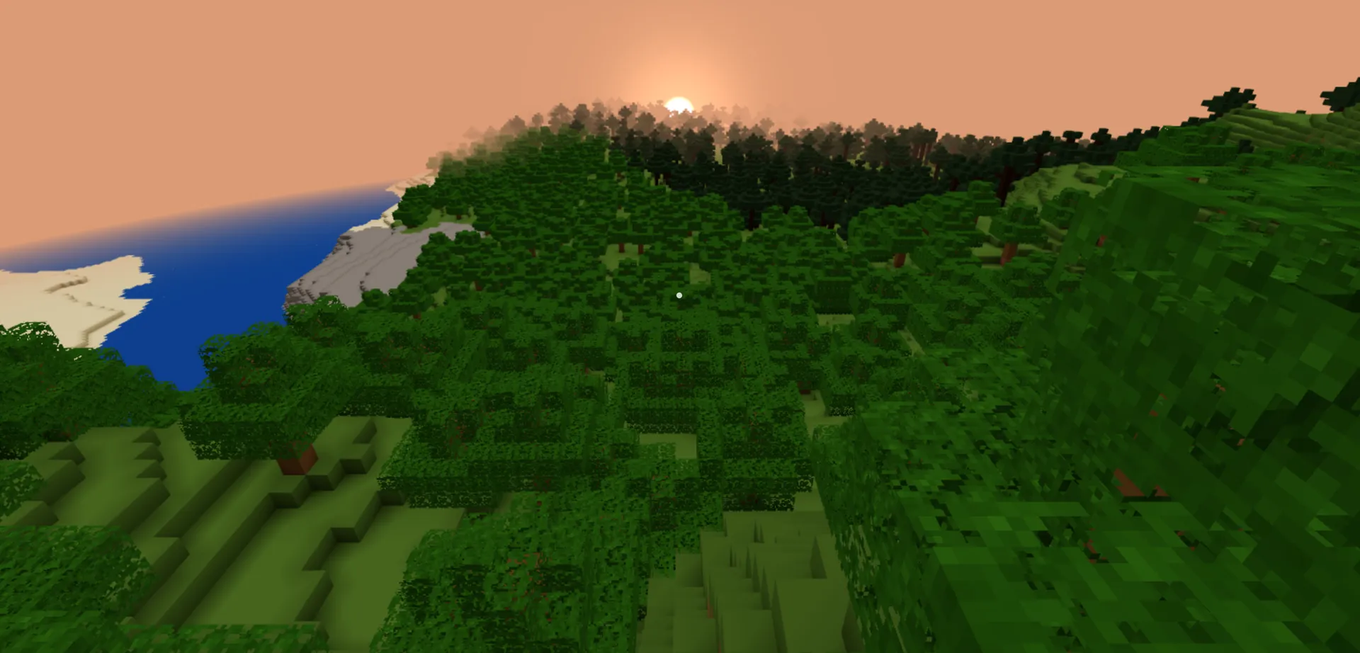 The sun setting behind a forested ridge above a bay with a pale sand shore.