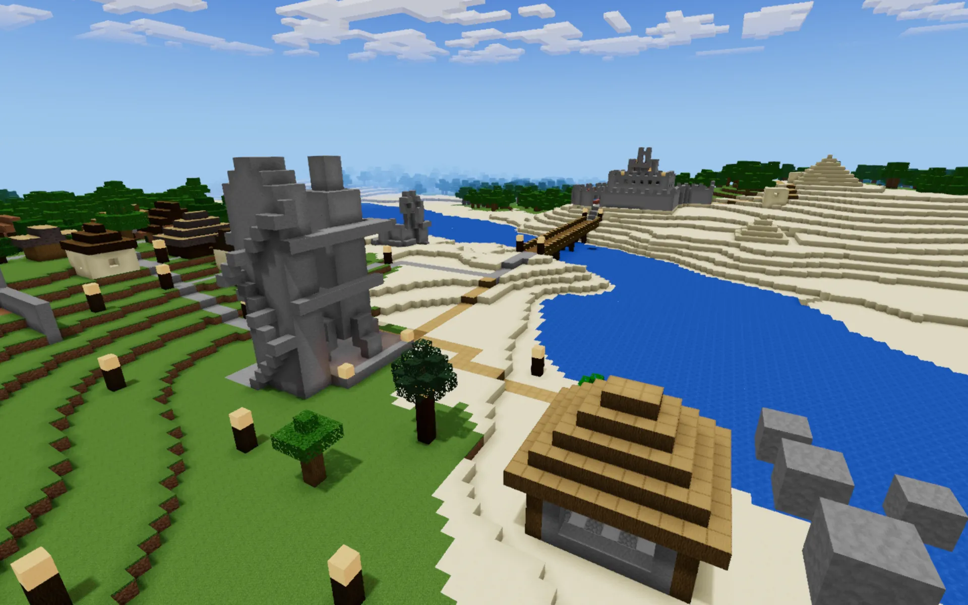 A blocky riverside township with a stone keep, a wooden bridge and terraced fields under a bright sky.